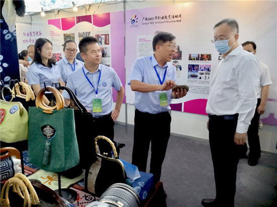 1623741553326335.jpg 自治区副主席黄俊华参观我校展位,陈黔校长为黄副主席讲解我校特色马尾绣手工艺品.jpg